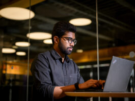 Sai Panindra Santosh Kumar Majji sitting at a desk working at a laptop.