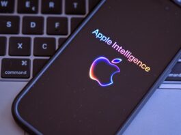 An iPhone with the Apple Intelligence logo on top of a MacBook keyboardm