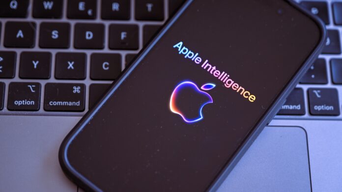 3zSeAUVBxRbFfAReQYq65k.jpg An iPhone with the Apple Intelligence logo on top of a MacBook keyboardm
