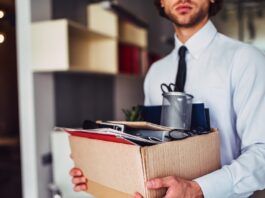 Man carrying a cardboard box of desk supplies 