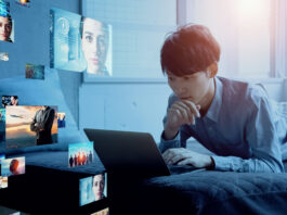 Young man on his laptop looking at images and videos
