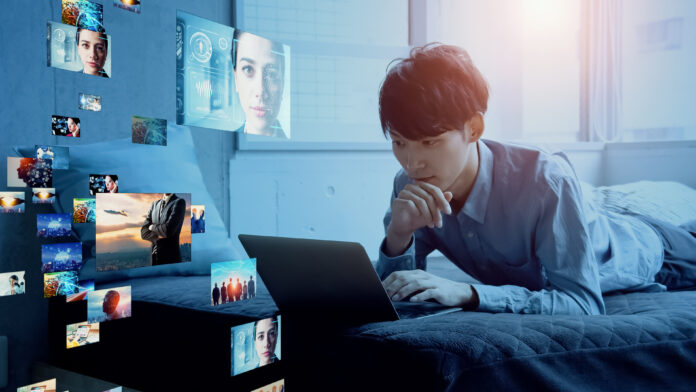 T523ZJ77htVP5UYdUaKHSX.jpg Young man on his laptop looking at images and videos