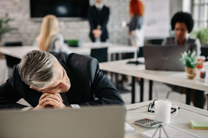 Mid adult businessman feeling depressed at work.