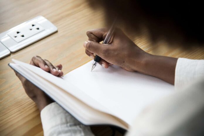 Rear view of woman writing a note
