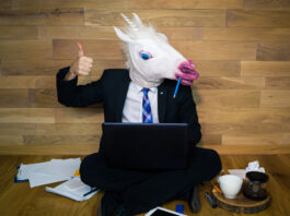 Business man wearing unicorn mask.