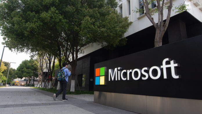 Microsoft headquarters in Shanghai, China, pictured with male employee walking in front entrance.