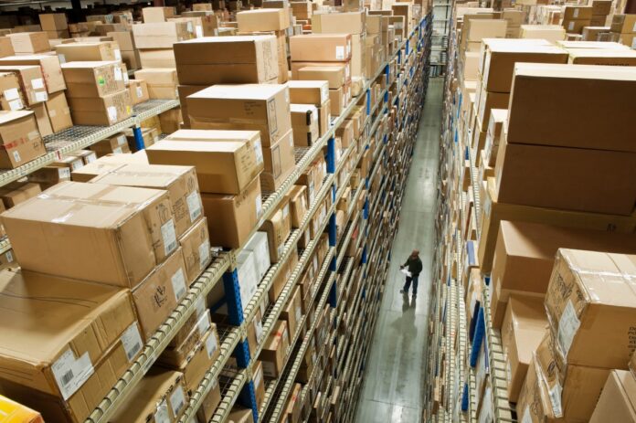 Man taking inventory in warehouse, aerial view