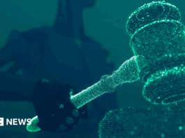 A robot holding and lowering a judge's gavel.