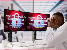 Man looking at computer screens displaying ranswomware messages.