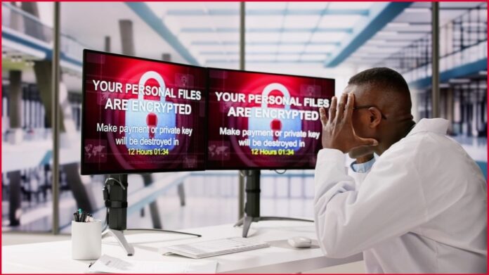 Man looking at computer screens displaying ranswomware messages.