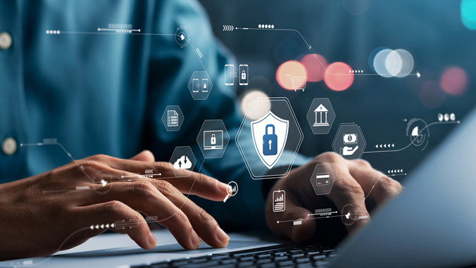cybersecurity-gnrc.jpg hand typing at laptop and icons across photo
