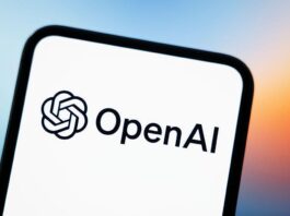 This photograph shows a smartphone screen displaying the logo of OpenAI.