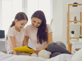 mother and child reading a book together on a bed