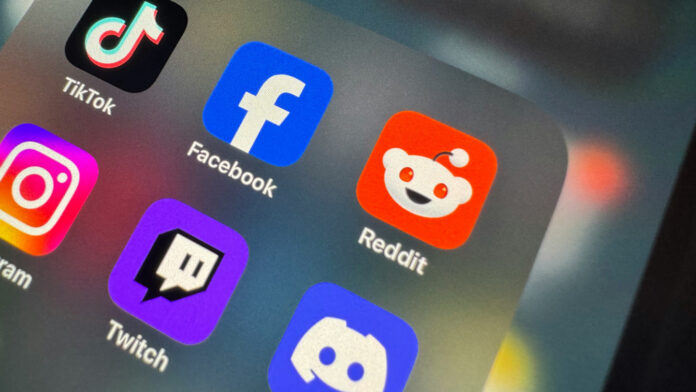 Several social media app icons on a screen, including ones for Reddit, Facebook and TikTok.