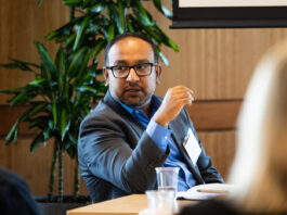 Doctor Abishek Murthy sitting at a table and gesturing toward two colleagues.