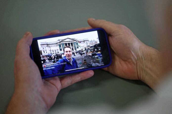 2025-10-14_09-03-22_977621.jpg An AI-generated video of London in decline is shared on the social media site X account of British far-right activist Tommy Robinson is viewed on a smart phone in London.