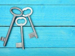 Top view of three 3 keys on a wooden blue table
