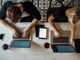 Coworkers using Mac laptops shot from above