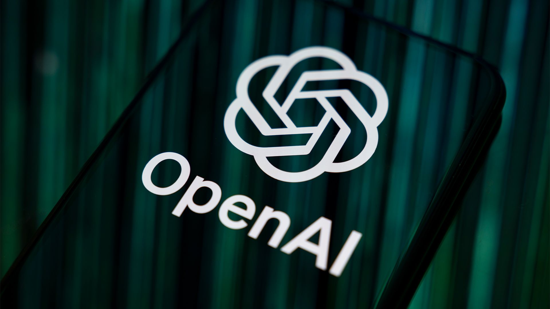 8aKDCf5QfKuUVFmUBc3Fgf-1920-80.jpg Close-up image of OpenAI logo and branding displayed on a smartphone screen.