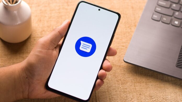 DxT7mFYFXDJfAYwZE5xgYH-1920-80.jpg A phone displaying the Google Messages logo