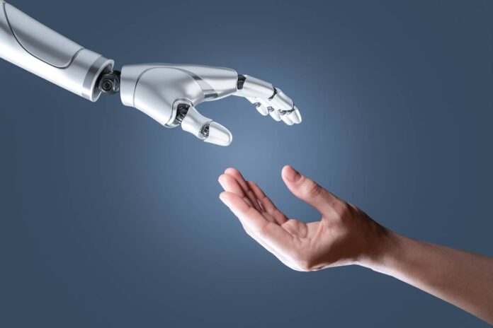 GettyImages-1467639088.jpg robot and human hand