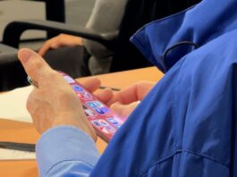 An attendee at the Albany Guardian Society AI and Aging symposium navigates apps on his iPhone.