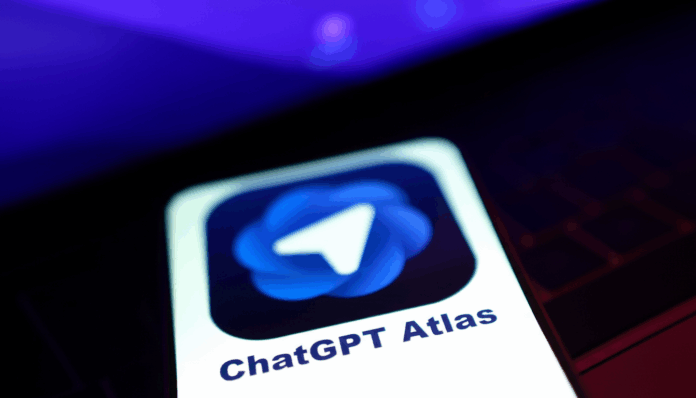 openai_atlas_browser_edited_1761489409.png A smartphone screen displaying the ChatGPT Atlas app icon, which features a white paper airplane symbol on a blue, swirling background. The phone is angled, with a blurred purple and dark background.