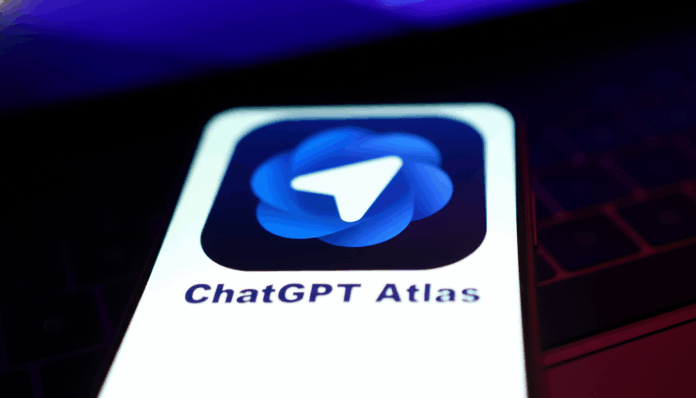 openai_atlas_kicks_off_ai_browser_audience_debate_edited_1761520354.png A smartphone screen displaying the ChatGPT Atlas app icon, which features a blue, swirling design with a white paper airplane symbol in the center. The phone is held against a dark, out-of-focus background with hints of purple light.