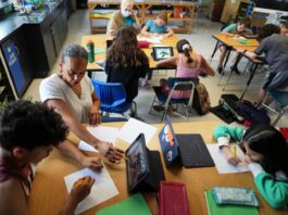 Art teacher Lindsay Johnson, second from left, teaches students how to ask ChatGPT for help during a summer class at Roosevelt Middle School in River Forest, Ill., on June 25.