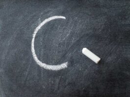 The letter C written on a blackboard with chalk stick.