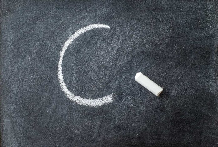 The letter C written on a blackboard with chalk stick.