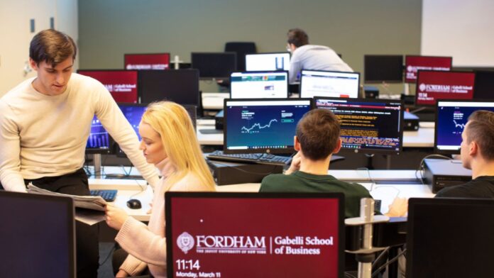 Students at the Gabelli School of Business study value investing in the trading room