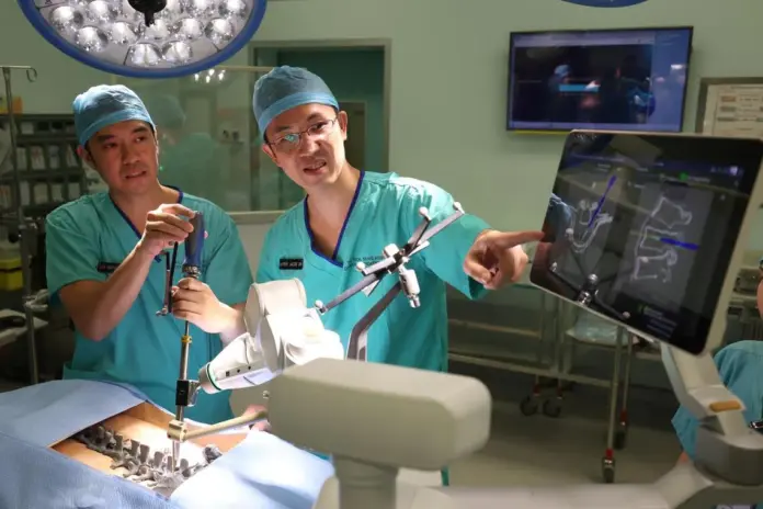 Adj A/Prof Jacob Oh (right), head of spine surgery and a senior consultant from the department of orthopedic surgery at TTSH, and Dr Wayne Yap, a consultant from the same department, demonstrating how the AI tool assisted the planning and execution of complex spine surgeries.