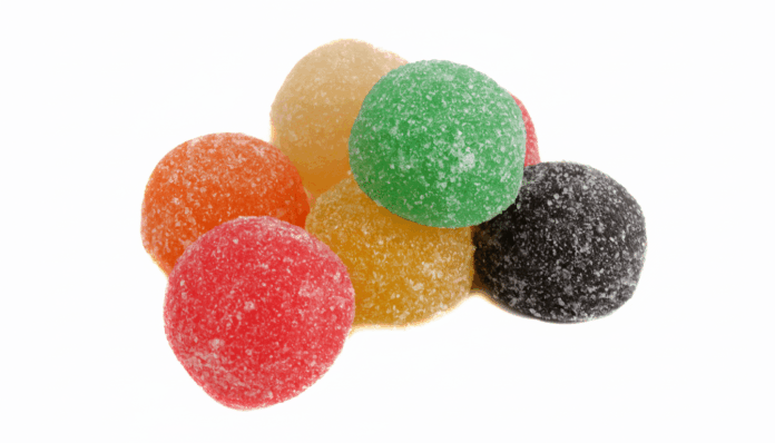 A pile of colorful, sugar-coated gumdrop candies on a white background.