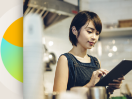 Transforming Retail with Dynamics 365 and AI Solutions A female retail employee works on a tablet in her shop.