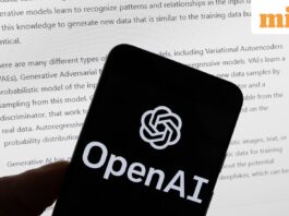 The OpenAI logo is displayed on a mobile phone in front of a computer screen with output from ChatGPT,