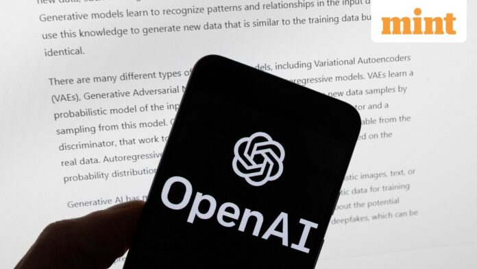 The OpenAI logo is displayed on a mobile phone in front of a computer screen with output from ChatGPT,