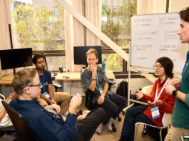 A digital wireframe human face on the right merges with an abstract circuit board design on the left, symbolizing the connection between technology and humanity.