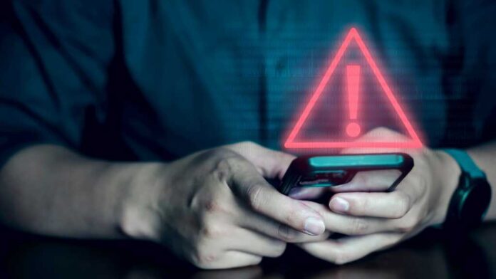 Man on phone with security alert warning