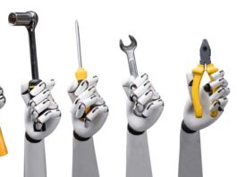 Close-up of robot hands holding tools on white background