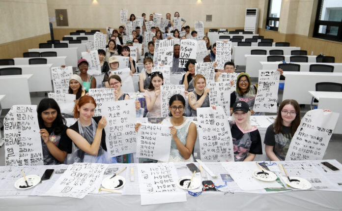 International students hold up their brush calligraphy works during a traditional calligraphy experience session at the “2025 Pusan National University Summer School,” held on July 9, 2025 at Pusan National University in Geumjeong District, Busan.