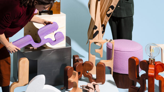 people handling wooden pieces as part of a student design project