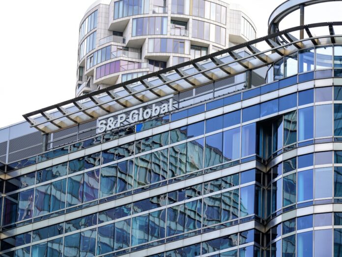 An office building with glass panels with an 'S&P Global' logo on the top floor.