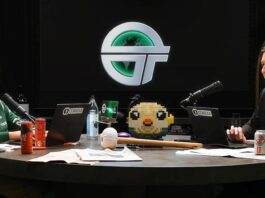 The two hosts of the TBPN show chat at their desk.